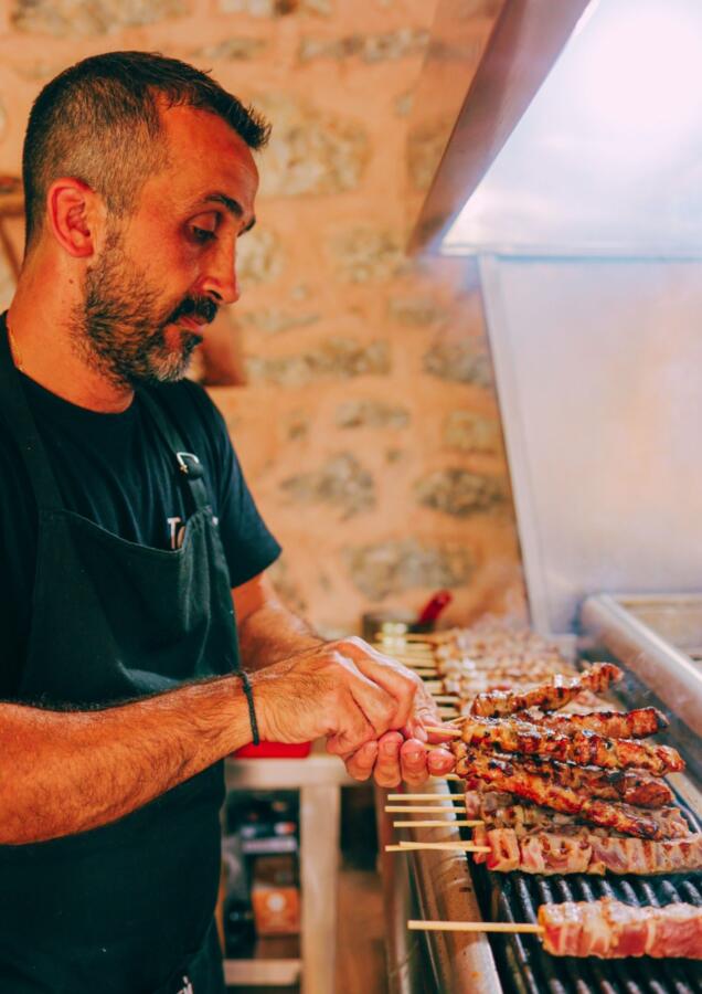 Γραφικό παραδοσιακό street food στέκι με τραπέζια και πολύχρωμες ομπρέλες στην καρδιά της Αρεόπολης epagelmaties.com.gr